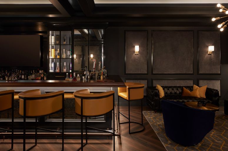 Moody dark custom built basement bar with lighting