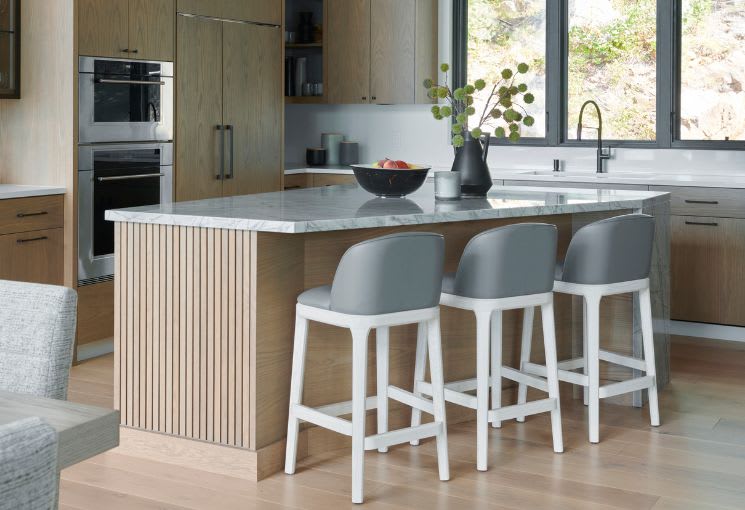 Modern white oak kitchen with grey and white barstools