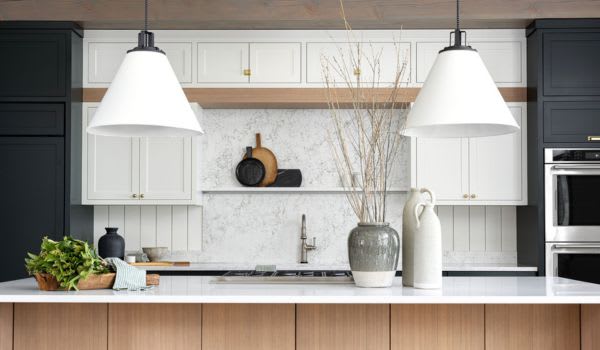 White and dark grey painted kitchen cabinets with modern lights hanging above island