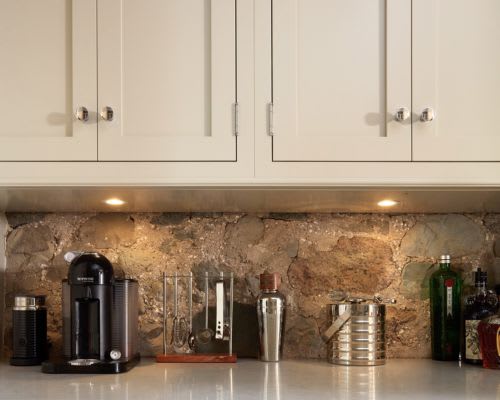 Close up of silver round knobs on white kitchen cabinets