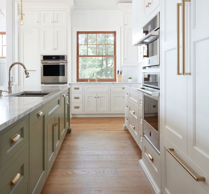 Green and white kitchen with a mix of pull and handle hardware