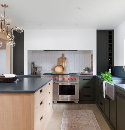 Dark custom cabinets in kitchen with wooden kitchen island