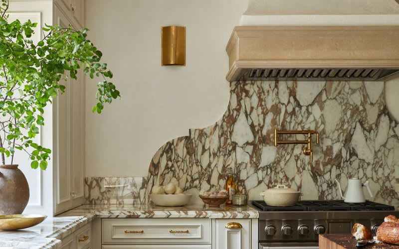 Marble curved wall back splash in european inspired kitchen