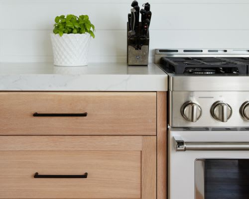 Close up of matte black handles on custom kitchen cabinets.